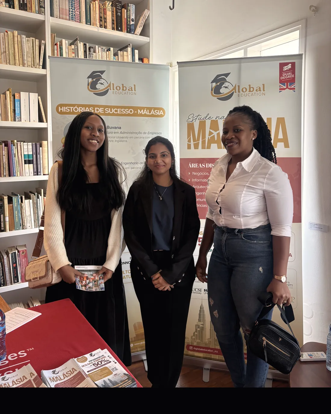Students with the team beside the success stories banners