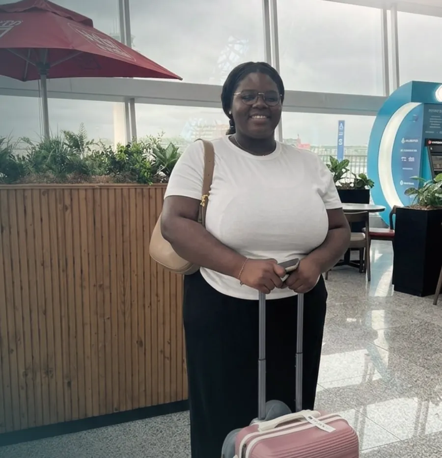 Student at the airport with her suitcase, ready to leave